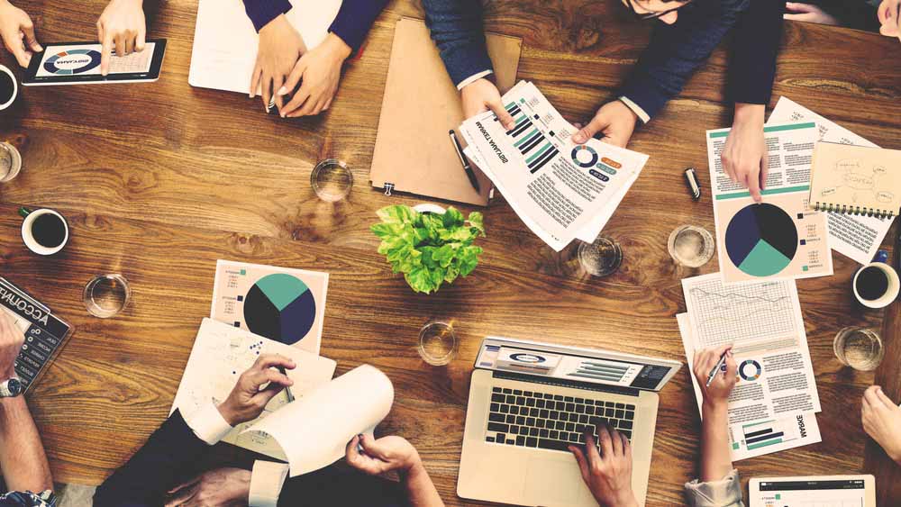 A vibrant and diverse group of Asian entrepreneurs discussing ideas in a modern co-working space