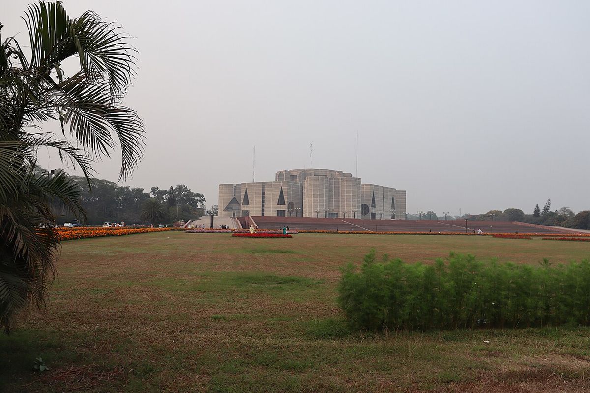 Bangladesh National Parliament building, Jatiya Sangsad Bhaban, seen across open lawns and flower beds in Dhaka
